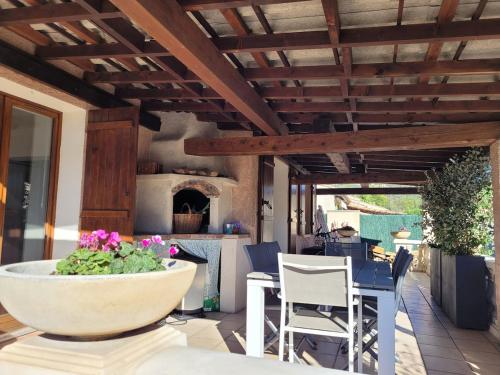 d'une terrasse avec une table, des chaises et un four à pizza. dans l'établissement Coquette maison 3 chambres, climatisée, à Grasse Côte d'Azur, à Grasse