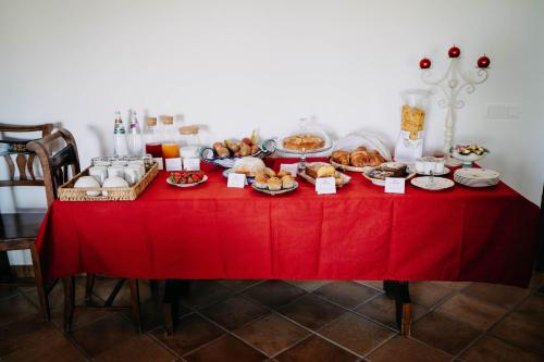 a table with a red table cloth with food on it at Tenuta Le Tre Rose in Vibonati
