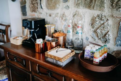 a wooden table with a coffee maker and bottles on it at Tenuta Le Tre Rose in Vibonati