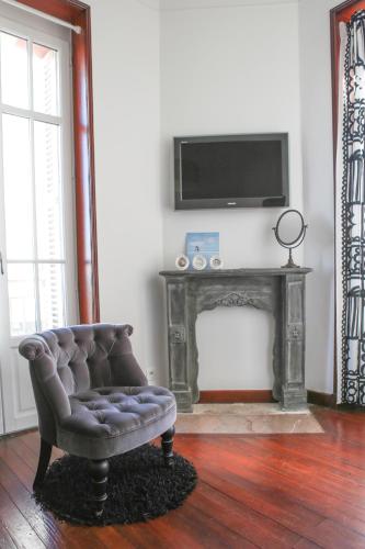 - un salon avec une chaise et une cheminée dans l'établissement Les Bruyères, à Les Sables-dʼOlonne