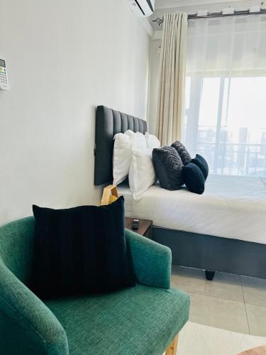 ein Schlafzimmer mit einem Bett, einer Couch und einem Stuhl in der Unterkunft White Oasis in Gaborone