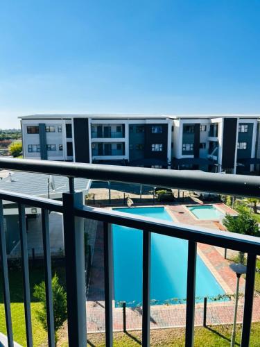 Blick vom Balkon eines Gebäudes mit Schwimmbad in der Unterkunft White Oasis in Gaborone