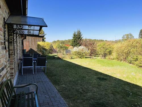 a patio with a table and chairs on a lawn at Ferienhof Rätzsee in Drosedow