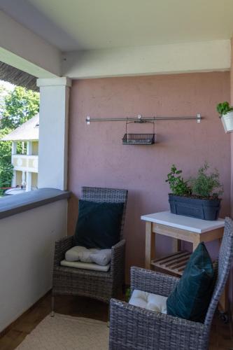 a patio with two chairs and a table on a patio at Seepark Weiden - Baumhof in Weiden am See
