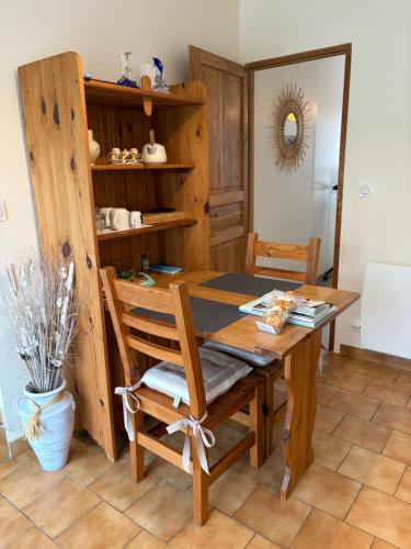 a dining room with a wooden table and a chair at Le paradis des oiseaux in Saint-Gildas