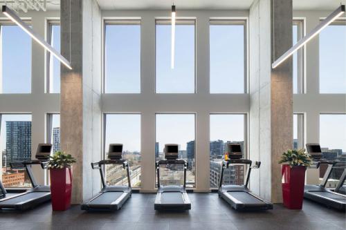 a gym with cardio equipment in a building with windows at Moxy Montreal Downtown in Montréal
