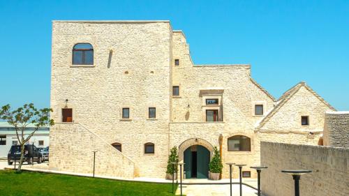 a large brick building with a gate in a yard at Masseria Surace in Noci
