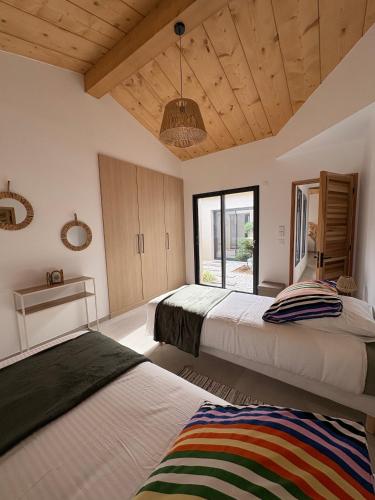 deux lits dans une chambre avec une fenêtre dans l'établissement NEW Maison b Saint-Paul 8 Visiteurs, à Saint-Paul-de-Vence