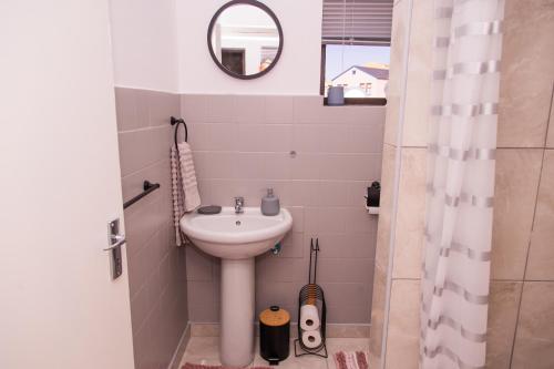a small bathroom with a sink and a mirror at The View Apartment 3 in Lüderitz
