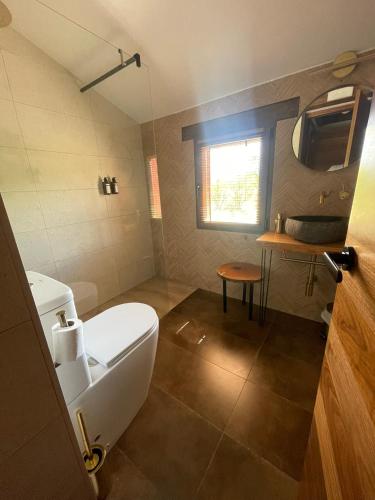 a bathroom with a white toilet and a window at La Casa del Cantero in Pinilla del Valle