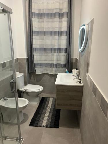 a bathroom with a toilet and a sink and a shower at Little House On The Sea in Acireale