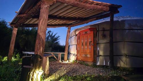 a small house with a wooden door and a roof at DuVa mongolska yurta in Bistrica