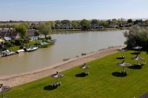 a group of umbrellas on the grass next to a river at Seepark Weiden - Baumhof in Weiden am See