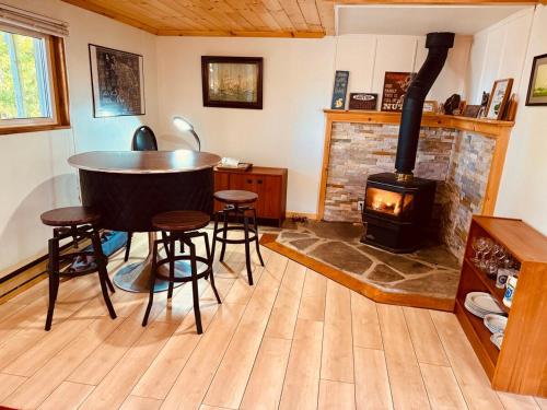 a living room with a table and a wood stove at All Star Inn cottage on water with stunning sunsets in Tobermory
