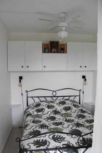 - une chambre avec un lit et des armoires blanches dans l'établissement Appartement cosy à Port Camargue, au Grau-du-Roi