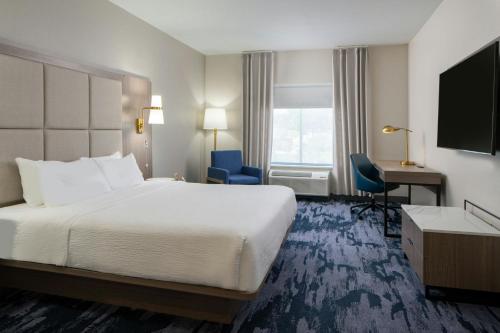 a hotel room with a large bed and a desk at Fairfield Inn & Suites by Marriott Lafayette South in Lafayette