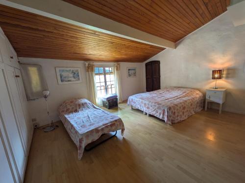 une chambre avec deux lits et un plafond en bois dans l'établissement Maison Martina, à Castellane