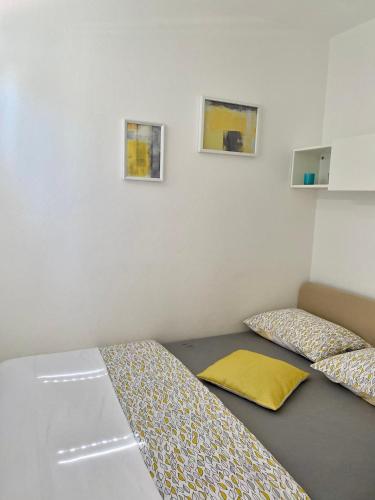 a bedroom with two beds and two pictures on the wall at Studio Lokvica in Omišalj