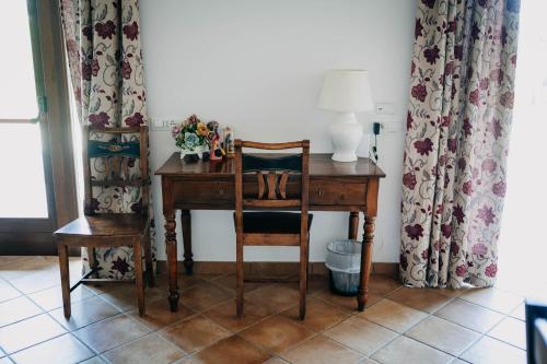 a desk with a chair and a lamp on it at Tenuta Le Tre Rose in Vibonati
