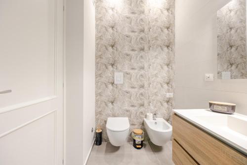 a white bathroom with a toilet and a sink at IVY - Boston in Latina