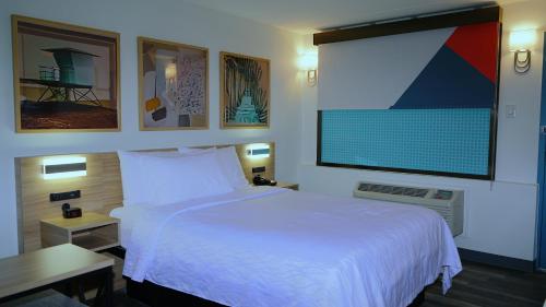 a bedroom with a white bed and a large screen at Waterfront Inn PHL Airport in Essington