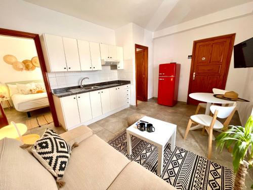 a living room with a couch and a red refrigerator at Weybeach2 -shared terrace,plaza view,sea frontline in La Santa