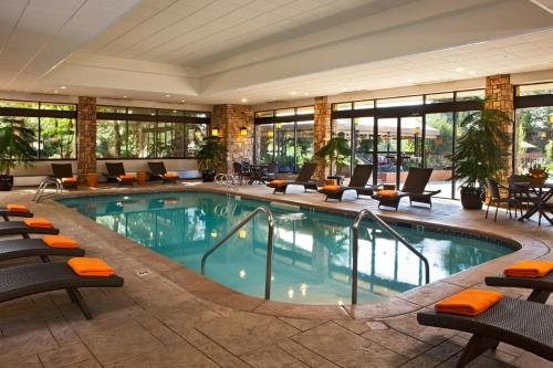 a pool in a hotel lobby with chairs and tables at Denver Marriott West in Golden
