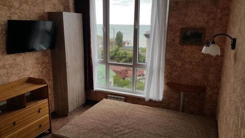 ソチにあるАпартаменты на Крымскойのベッドルーム1室(家の景色を望む大きな窓付)