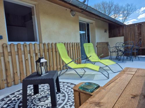 une terrasse avec des chaises, une table et une télévision dans l'établissement Villa Brocéliande - Les Tilleuls, à Soulac-sur-Mer