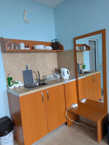 a small kitchen with a sink and a mirror at Guest House Chalakov in Sinemorets