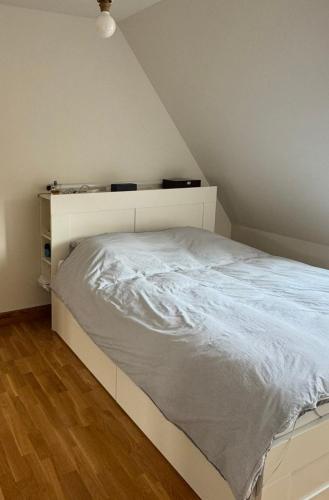 Ce lit se trouve dans un dortoir doté d'un cadre de lit blanc. dans l'établissement Chambre confortable proche Stade Pierre Mauroy, à Sainghin-en-Mélantois