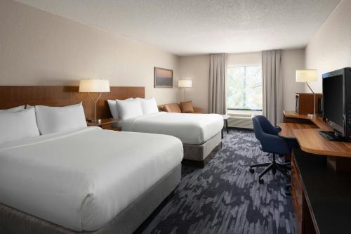 a hotel room with two beds and a desk and a television at Fairfield Inn and Suites by Marriott Tifton in Tifton
