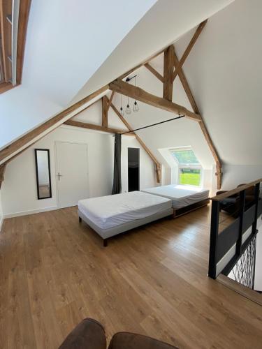 une grande chambre avec un lit dans le grenier dans l'établissement La maison des prés, à Guérande