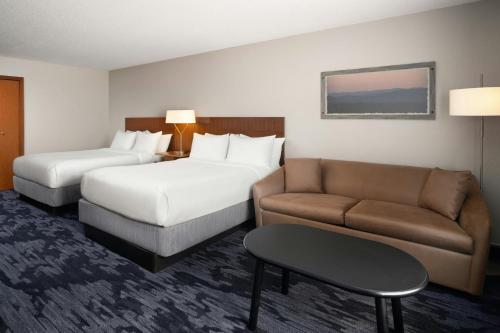 a hotel room with two beds and a couch at Fairfield Inn and Suites by Marriott Tifton in Tifton