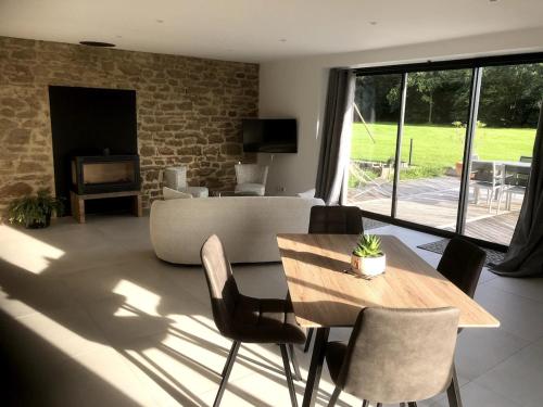 un salon avec une table et des chaises en bois dans l'établissement La maison des prés, à Guérande