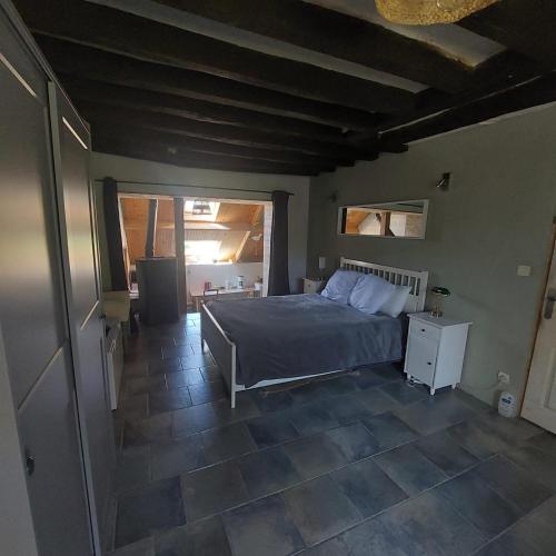 a bedroom with a bed and a large window at Maison au calme avec jardin exotique pour 7 personnes in Thorigné-sur-Dué