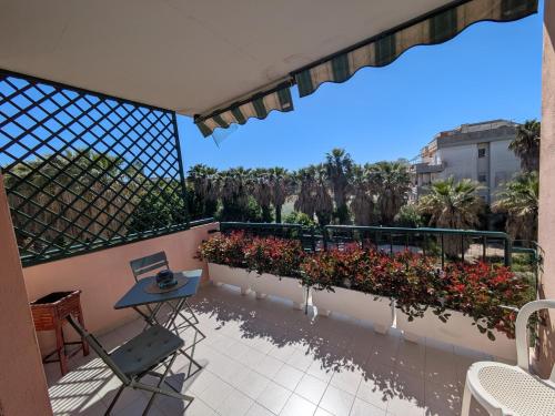 a balcony with a table and chairs and flowers at Orchidea Borghese in Nettuno