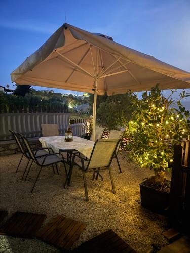 a table and chairs under an umbrella on a patio at Koroni Dream House in Koroni