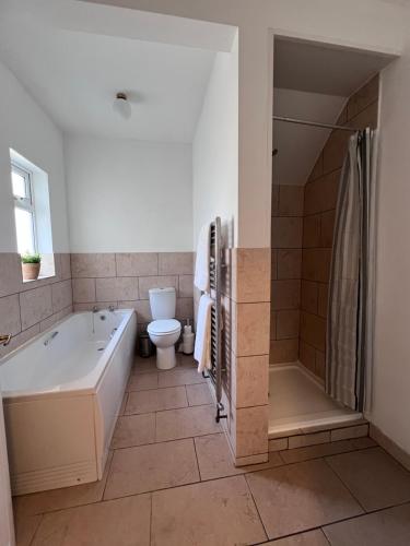 een badkamer met een bad en een toilet bij The Nest at Amble in Amble