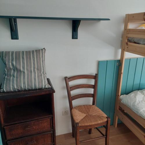 a room with a chair and a desk and bunk beds at Maison au calme avec jardin exotique pour 7 personnes in Thorigné-sur-Dué