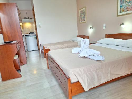 a hotel room with two beds with towels on them at George Studios in Vasiliki