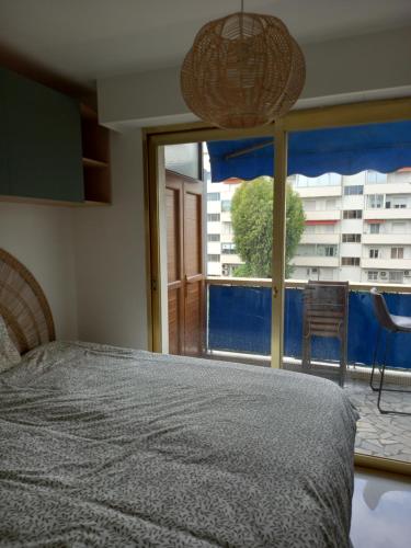 une chambre avec un lit et une grande fenêtre dans l'établissement Grandlarge, à Cagnes-sur-Mer