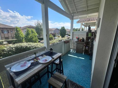 une véranda avec une table et des chaises dans l'établissement Agréable appartement sud Landes, à Saint-Vincent-de-Tyrosse