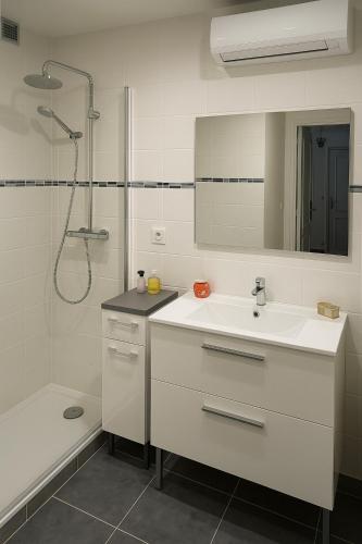 a white bathroom with a sink and a shower at Grande maison familiale avec jardin- 10 pers au coeur du Bearn in Guinarthe-Parenties