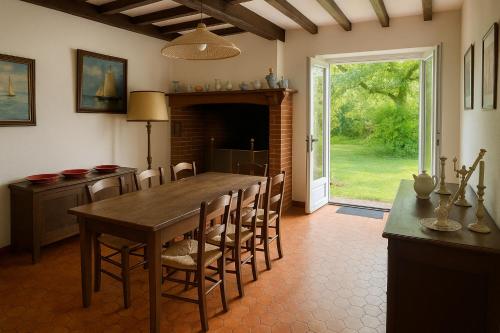 une salle à manger avec une table et des chaises en bois dans l'établissement Maison Mirande- Grande maison de campagne familiale entre mer et montagne tout confort très bien équipée, à Guinarthe-Parenties