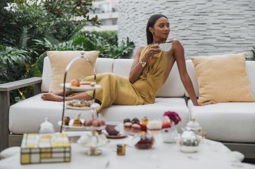 a woman in a yellow dress sitting on a couch at The St. Regis Mexico City in Mexico City