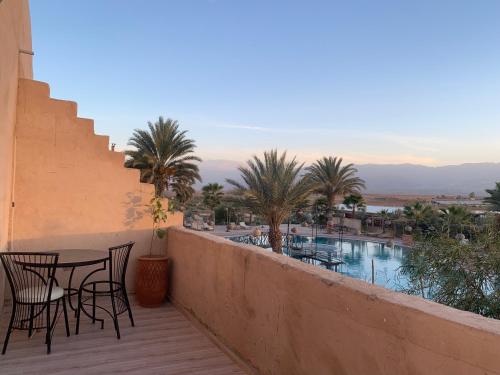 a balcony with tables and chairs and a swimming pool at Les Jardins d Amizmiz 6 piscines in Marrakech