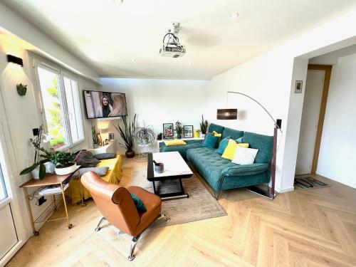 un salon avec un canapé bleu et une table dans l'établissement Duplex Rennes centre ville gare, à Rennes