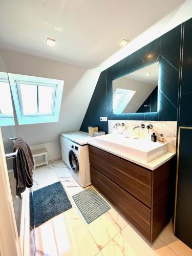une salle de bain avec un lavabo et une machine à laver dans l'établissement Duplex Rennes centre ville gare, à Rennes