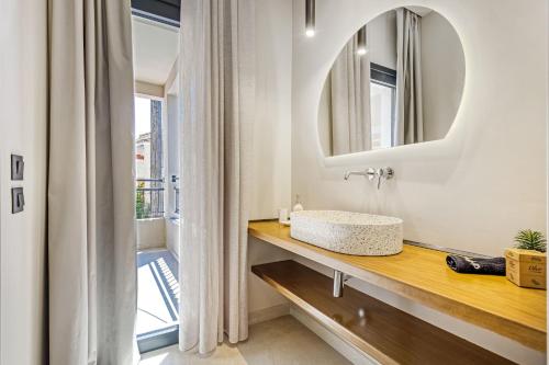 łazienka z umywalką i lustrem w obiekcie Almyra Apartments & Studios w mieście Agios Gordios